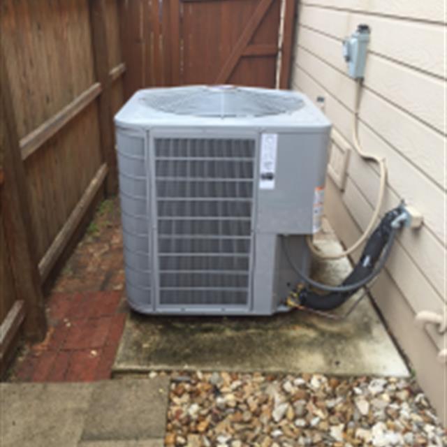 Air conditioning condenser unit outside a home.