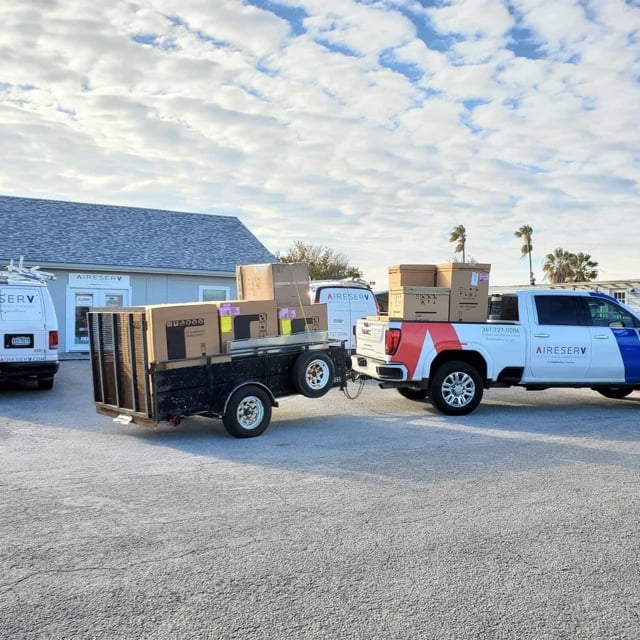 Aire Serv truck pulling a trailer with boxes