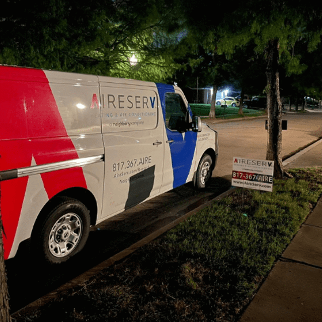 Aire Serv van beside Aire Serv sign at night