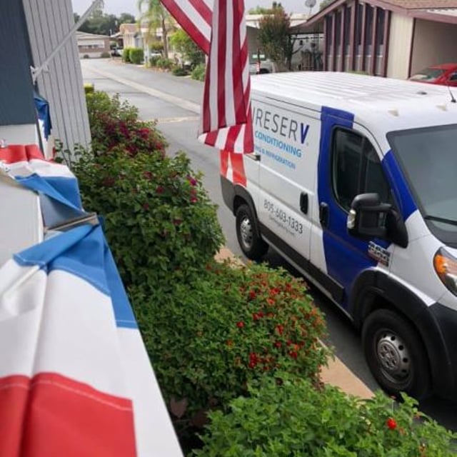 Aire Serv van parked outside under an American Flag