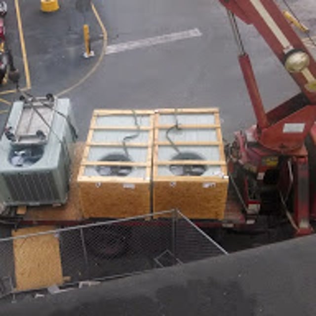 HVAC Units on bed of truck with crane lifting new condenser unit.