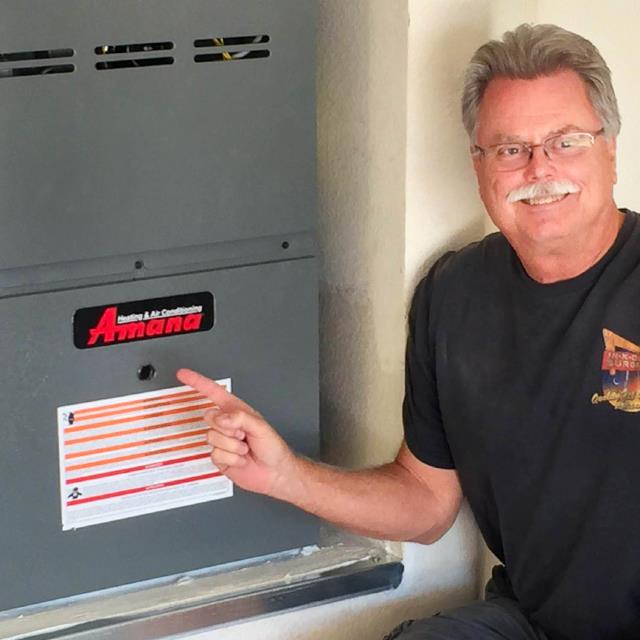 A man with glasses pointing to his new heater