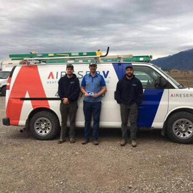 Three technicians in front of a van