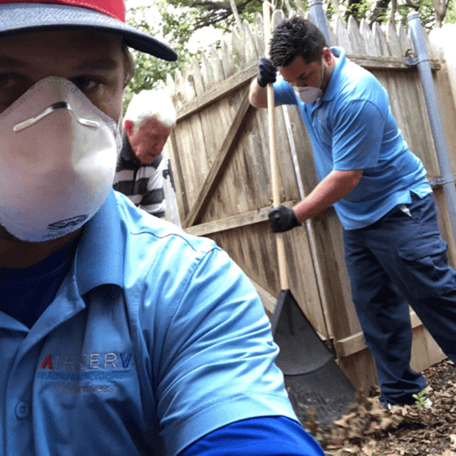 Two Aire Serv pros raking near the fence line