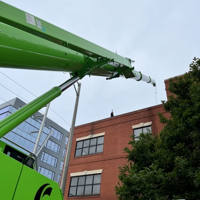 green crane extended over roof