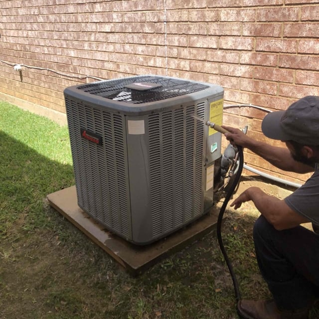 man cleaning ac unit