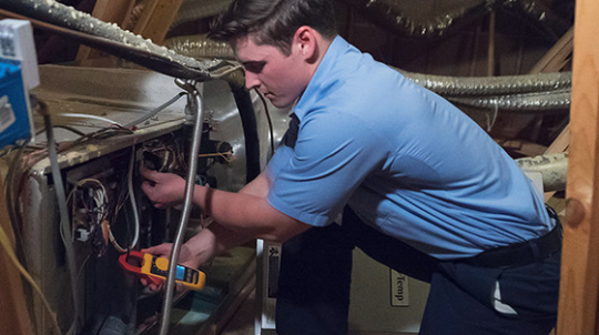 Male Aire Serv technician repairing a unit.