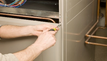 Repair Technician Removing Furnace Service Panel | Aire Serv of Springfield Illinois