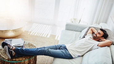 Shot of a man relaxing on the sofa at home | Aire Serv® of Springfield, IL