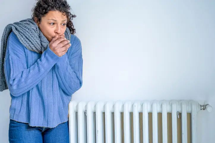 Black woman with home heating problem feeling cold | Aire Serv of Birmingham.