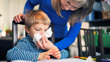 Mother helping her son blow his nose.