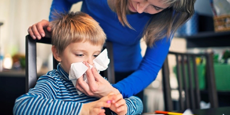 Child blowing his nose.