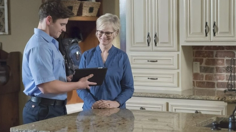 An HVAC service professional from Aire Serv speaking with a homeowner about her needs for a furnace tune up.