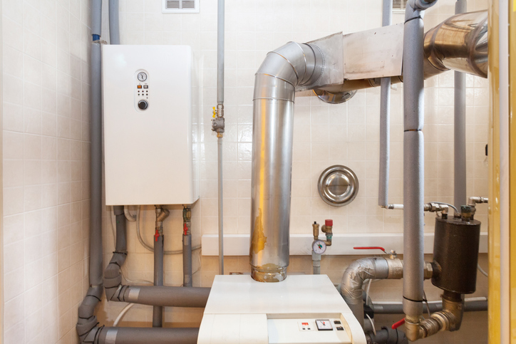 A domestic household boiler room with a new modern solid fuel boiler , heating electric warm water system and pipes.