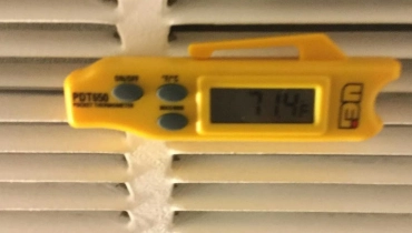 Digital thermometer being used by AC Company to test temperature of airflow in residential home