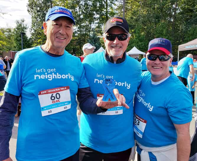 3 people in blue shirts smiling