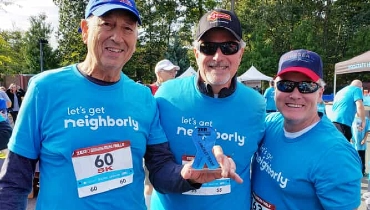 3 people in blue shirts smiling