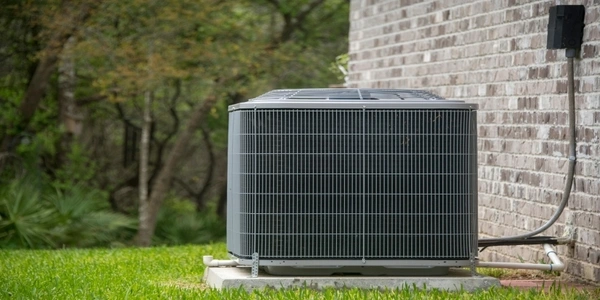 HVAC Air Conditioning Unit on concrete slap with new construction brick house