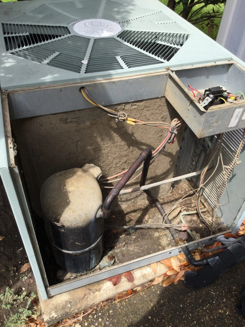 Outdoor AC unit maintenance underway with unit cover removed and wires visible.