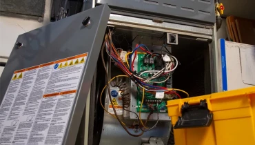 The inside of a furnace with wires exposed