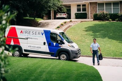 A courteous, uniformed Aire Serv ac tech walking up to a customer’s home.