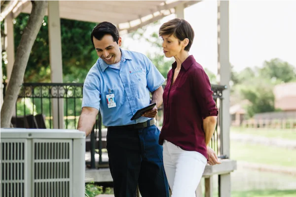 Aire Serv service professional reviewing HVAC service options with homeowner.