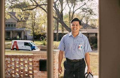 A professional Aire Serv AC replacement tech at a customer’s front door