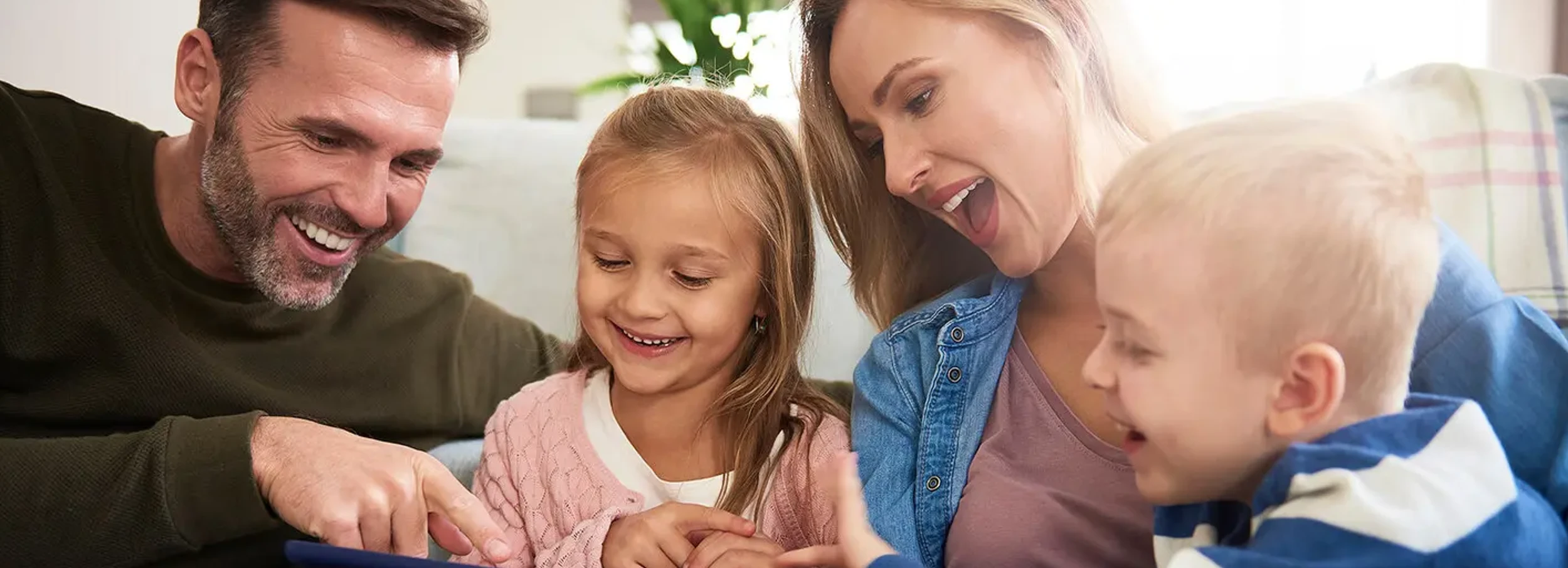 A happy family viewing a tablet.