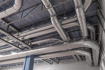 Exposed steel air ducts on a ceiling.