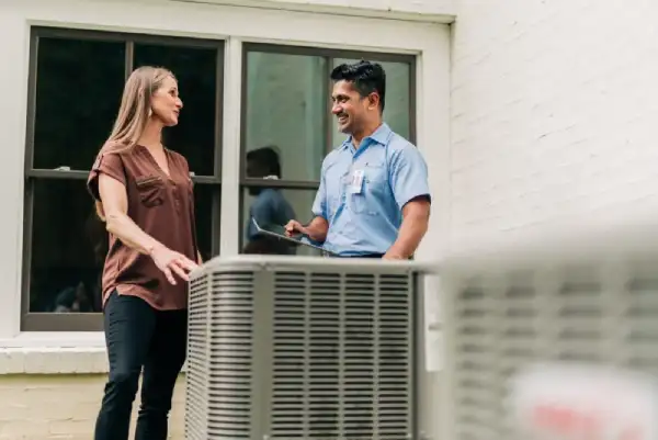 Aire Serv tech discussing air conditioner repair with female customer.