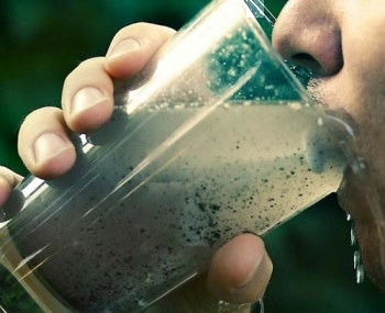 Person drinking water clouded with dirt