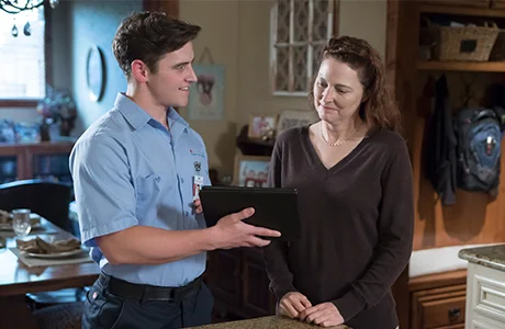 Man holding iPad talking to woman