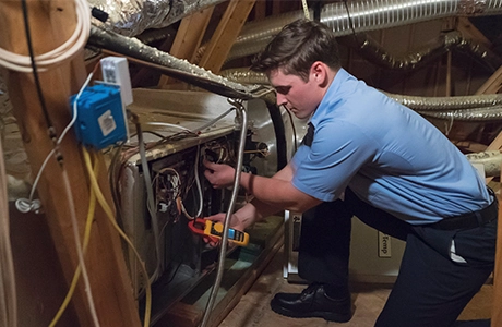 Aire Serv technician checking heater repair option at customer house.