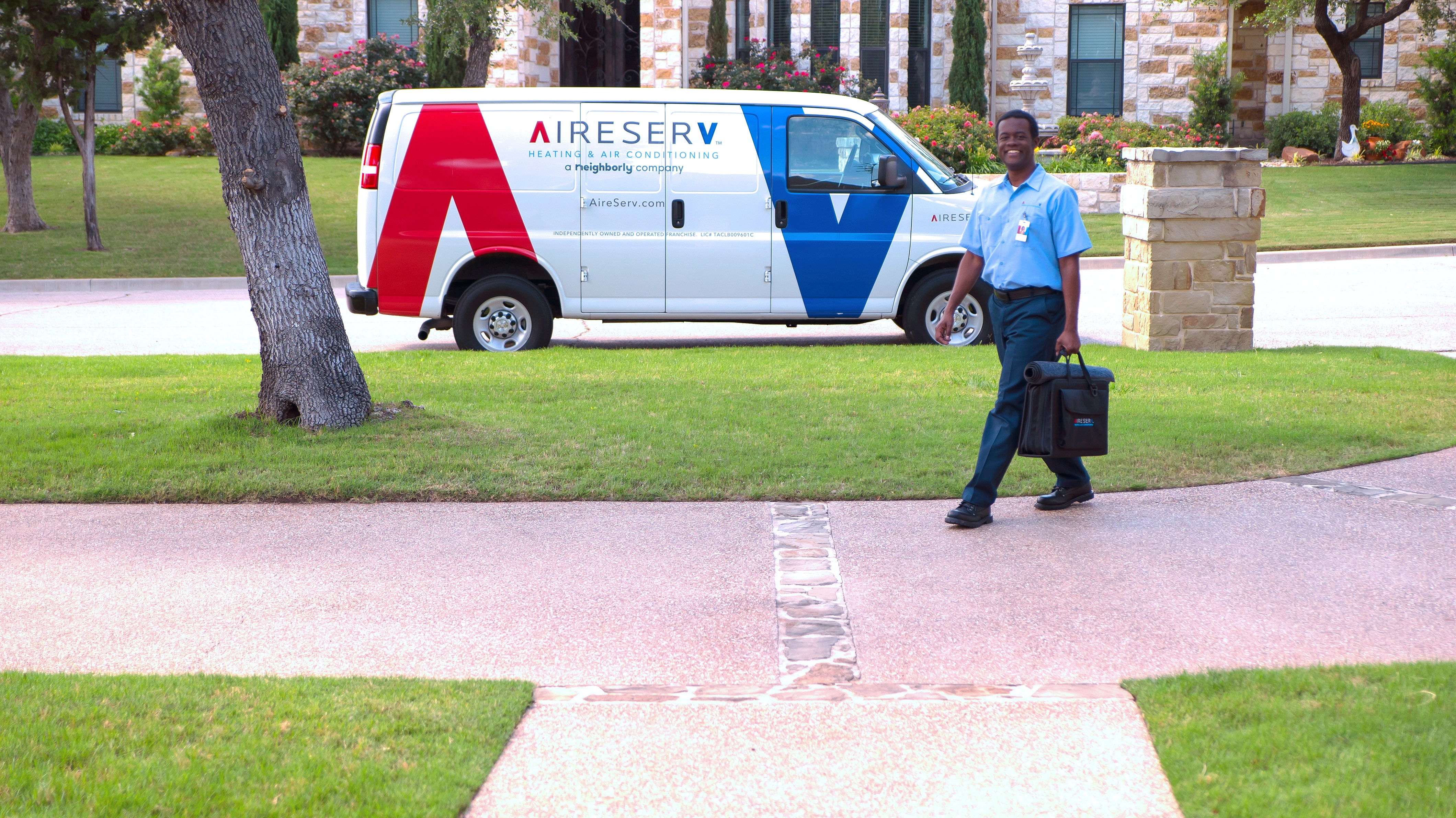 An HVAC service professional using an electronic tablet to show a lady an estimate for McKinney AC installation.