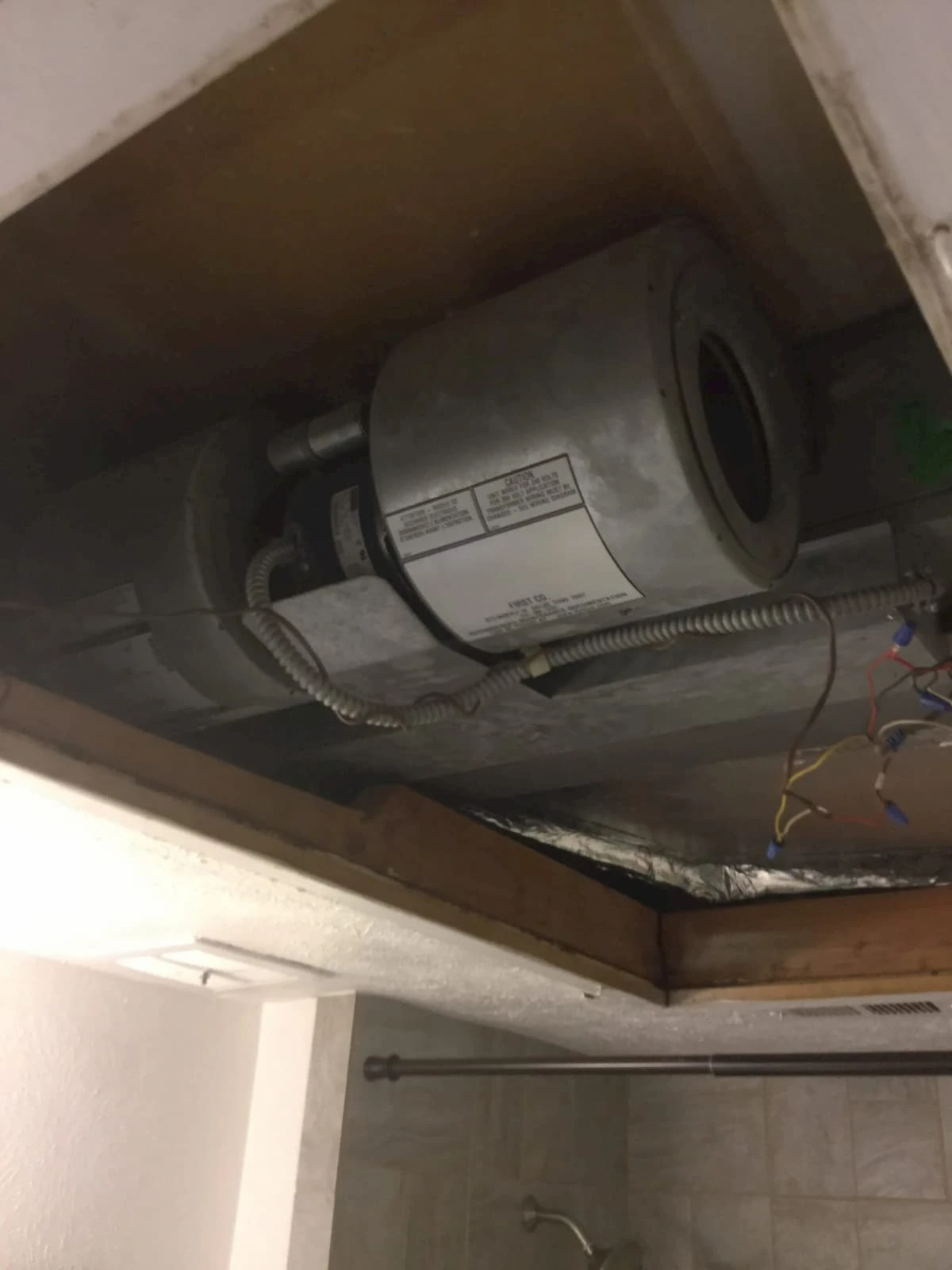 An HVAC system located in the ceiling of a basement, where it has been repaired by Aire Serv.