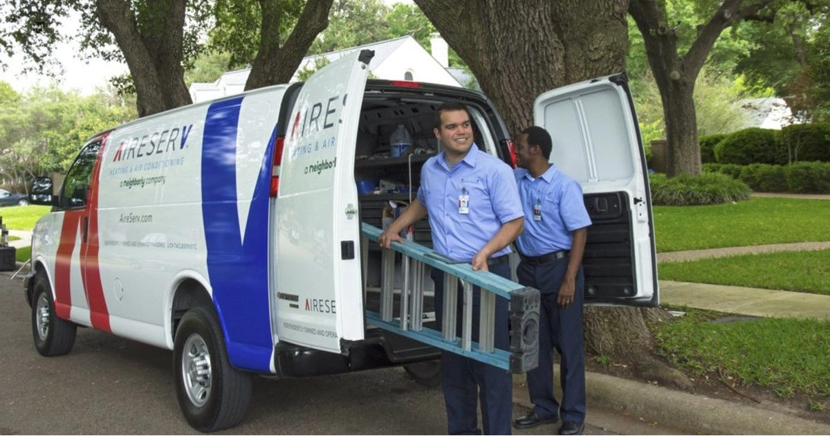 Two Wylie HVAC technicians bringing a ladder out of a van for a service job